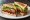 BLAT: an illustration of bacon, lettuce, tomato, avocado and more on white bread.