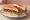 BLT: an illustration of bacon, lettuce, tomato and mayonnaise on white bread.