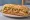 Bocadillo Completo: an illustration of pork, cheese, lettuce and tomato on baguette.