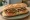 Bocadillo de Hamburguesa: an illustration of beef, onion, tomato and lettuce on baguette.