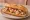 Bocadillo de Salpicón: an illustration of shrimp, octopus, onion, pepper and more on baguette.