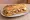 Bocadillo Gourmet: an illustration of pork, cheese and olive oil on baguette.