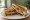 Bombay Sandwich: an illustration of butter, potato, cucumber, tomato and more on white bread.