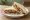 Bombay Vegetable Sandwich: an illustration of butter, potato, cucumber, tomato and more on white bread.