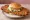 Breaded Pork Tenderloin: an illustration of pork, pickle, onion, lettuce and more on burger bun.