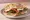 Brie and Bacon: an illustration of bacon, brie, arugula, cranberry sauce and more on ciabatta.