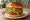 Brioche Burger: an illustration of beef, cheddar cheese, lettuce, tomato and more on burger bun.