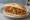 Broodje Bami: an illustration of pork, maggi seasoning sauce and cabbage on kaiser roll.