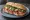 Broodje Carpaccio: an illustration of beef, parmesan, arugula and olive oil on kaiser roll.