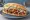 Broodje Döner: an illustration of chicken, lamb, lettuce, tomato and more.