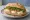 Broodje Geitenkaas: an illustration of goat cheese, honey, walnuts and arugula on kaiser roll.