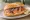 Broodje Gerookte Zalm: an illustration of salmon, cream cheese, dill and lemon on kaiser roll.