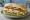Broodje Gezond met Kip: an illustration of chicken, lettuce, tomato, cucumber and more on kaiser roll.