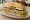 Broodje Gezond met Tonijn: an illustration of tuna, lettuce, tomato, cucumber and more on kaiser roll.