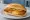 Broodje Kaassoufflé: an illustration of cheese and mustard on kaiser roll.