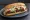 Broodje Kebab: an illustration of lettuce, tomato, onion and garlic sauce on kaiser roll.