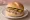 Broodje Paté: an illustration of pâté, butter and pickle on kaiser roll.