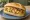 Broodje Pom: an illustration of chicken and onion on kaiser roll.