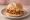 Broodje Pulled Chicken: an illustration of chicken, bbq sauce and coleslaw on kaiser roll.