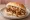 Broodje Saté: an illustration of chicken, pork and onion on kaiser roll.