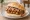 Broodje Saté Ajam: an illustration of chicken and onion on kaiser roll.