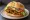 Broodje Seitan: an illustration of mock meat, lettuce, tomato and onion on kaiser roll.