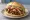 Broodje Shoarma Speciaal: an illustration of lamb, garlic sauce, sriracha, lettuce and more on kaiser roll.
