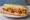 Buffalo Chicken Finger Sub: an illustration of chicken, butter, lettuce and tomato on hoagie roll.