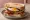 Builder's Sandwich: an illustration of bacon, sausage, egg and butter on white bread.