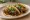 Bulgogi Taco: an illustration of beef, maggi seasoning sauce, onion and cilantro on tortilla.