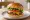 Burger Gourmet: an illustration of beef, cheddar cheese, lettuce, tomato and more on burger bun.