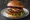 Burger z Oscypkiem: an illustration of beef, lettuce, tomato and onion on burger bun.