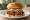 Burger z Pulled Pork: an illustration of pork, bbq sauce, coleslaw and pickle on burger bun.