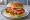 Burger ze Schabowym: an illustration of pork, egg, lettuce, tomato and more on burger bun.