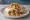 Burrito de Machaca: an illustration of beef, egg, onion and tomato on tortilla.