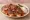 Bursa Pideli Kebap: an illustration of lamb, beef, marinara, yogurt and more on pita.