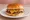 Butter Burger: an illustration of beef, butter, american cheese, onion and more on burger bun.
