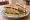California Club: an illustration of turkey, bacon, avocado, lettuce and more on white bread.