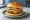 Cheeseburger: an illustration of beef, american cheese, pickle, onion and more on burger bun.
