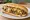 Cheesesteak Wit: an illustration of beef, cheese sauce and onion on hoagie roll.