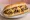 Cheesesteak Witout: an illustration of beef and cheese sauce on hoagie roll.