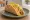 Cheesy Gordita Crunch: an illustration of beef, cheese and lettuce on tortilla.