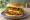 Chick-fil-A Deluxe: an illustration of chicken, american cheese, lettuce, tomato and more on burger bun.
