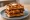 Chicken and Waffles Sandwich: an illustration of chicken, butter and maple syrup.