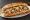 Chicken Cheesesteak: an illustration of chicken, provolone and onion on hoagie roll.