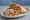 Chicken Shawarma: an illustration of chicken, garlic, tahini, pickle and more on pita.