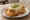 Chimichanga de Carne: an illustration of beef, cheese, sour cream and guacamole on tortilla.
