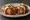 Chimichanga de Machaca: an illustration of beef, onion, tomato, pepper and more on tortilla.