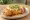 Chimichanga de Pollo: an illustration of chicken, cheese, sour cream and guacamole on tortilla.