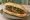 Choripán Clásico: an illustration of pork, sausage, chimichurri, parsley and more on baguette.